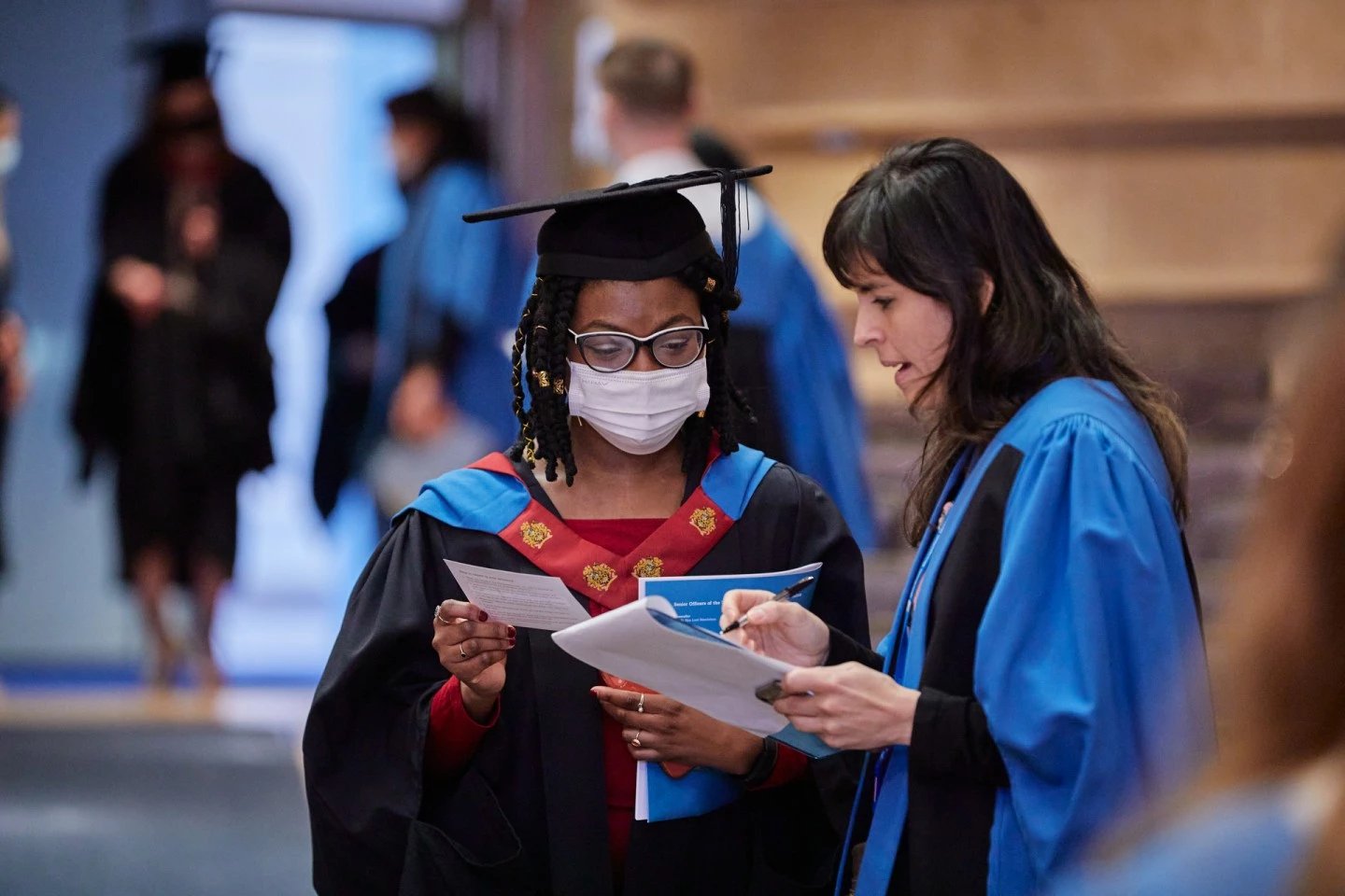 Two students receiving their degrees at graduation ceremony