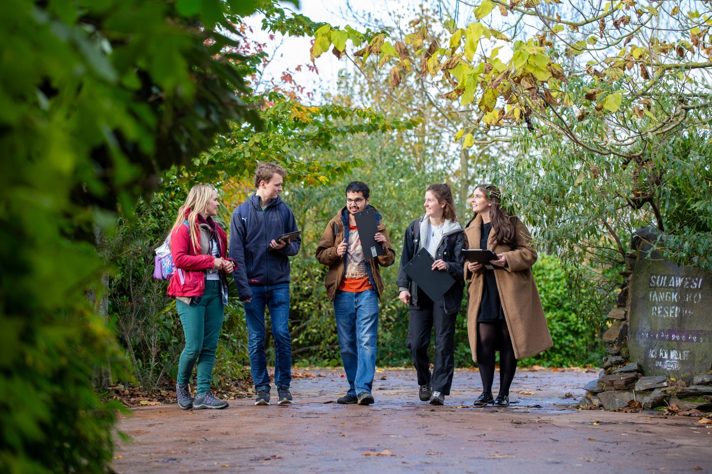 A group of students and staff walking between the trees at Chester Zoo