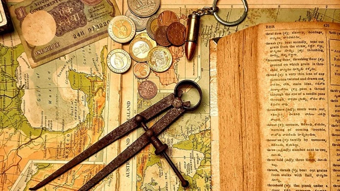 Image showing a map, compass, book and coins, all are yellowed or look old