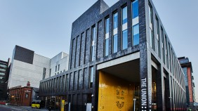 Modern Students' Union building, surrounded by a mix of old and new on-campus buildings in city setting