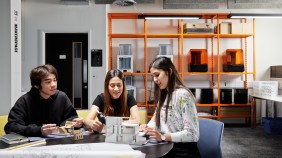 Group of architecture students in a studio space, engaged in work and surrounded by architectural models